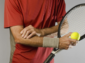 tennis player massaging elbow